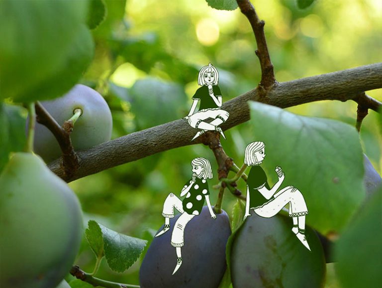 Drei gemalte Figuren auf einem Zwetschenbaum.