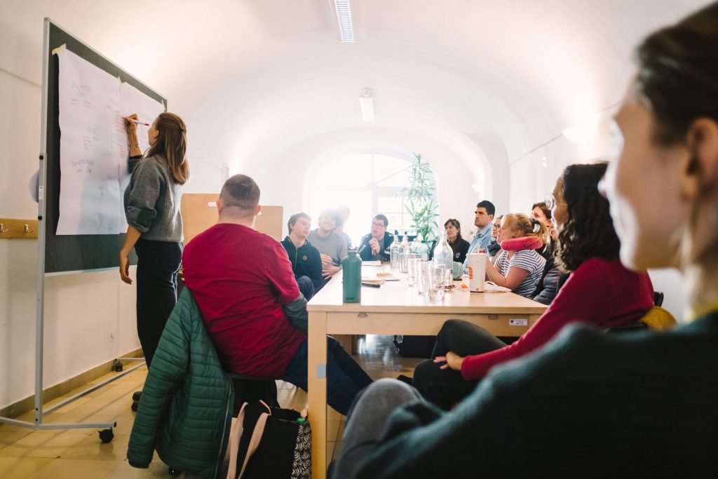 Das Team von andererseits sitzt um ienen Tisch und arbeitet gemeinsam