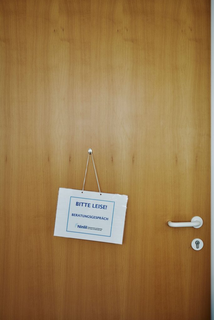 Das Bild zeigt eine geschlossene Tür an der ein Schild mit dem Titel "Bitte Leise" hängt.