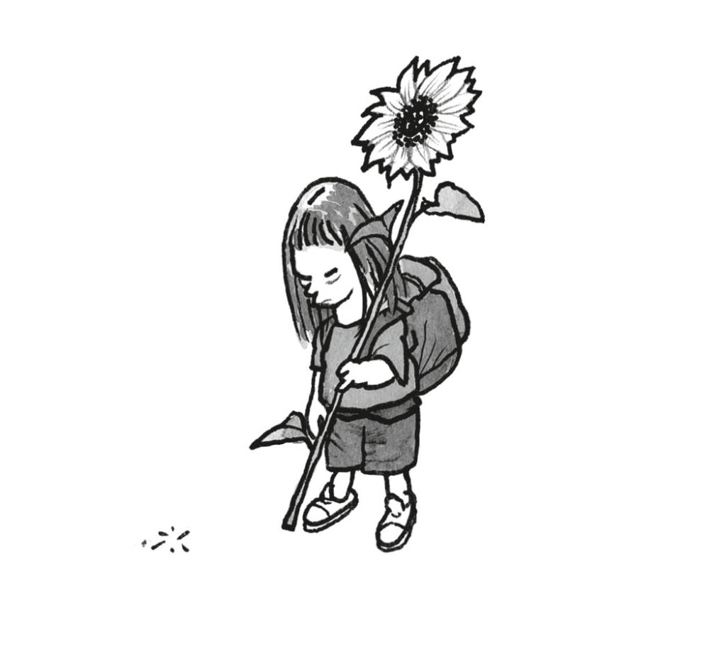 Eine Schülerin mit einer Sonnenblume in der Hand.